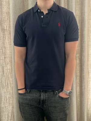 Ralph lauren piké | S  - Mörkblå Ralph Lauren piké | fint skick men har några slitningar (se bilder) | äldre modell, tröjan är något längre baktill | modellen är ca 180 |  hör av dig om du har funderingar🙌|