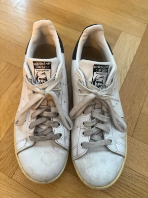 Adidas Stan Smith vita sneakers - Adidas Stan Smith i storlek: 40 2/3.   Använda och har tydligt slitage - gulnade sulor, märken och veck (se bilder). Inget är dock sönder och de är fortfarande fullt användbara!🩶