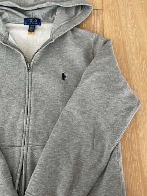 Grå hoodie från Polo Ralph Lauren - Grå Zip hoodie från Ralph Lauren i mycket bra skick, storlek junior (14-16) år