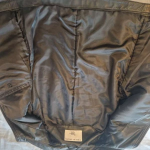 Svart läderjacka från Tiger of Sweden - Snygg svart skinnjacka från Tiger of Sweden med stilren design och diskreta sömmar. Jackan har dragkedja framtill med läderdetalj, innerfoder och klassisk krage. Perfekt för dig som vill ha en cool och tidlös look. Kostar 6 tusen kronor