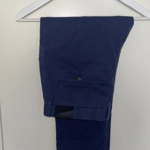 Marinblå chinos J.Lindeberg 31/32 - Snygga marinblå chinos från J.Lindeberg, modell Chaze Flannel Twill Pants. Byxorna har klassisk rak passform, stilrena chinos som sitter perfekt. 