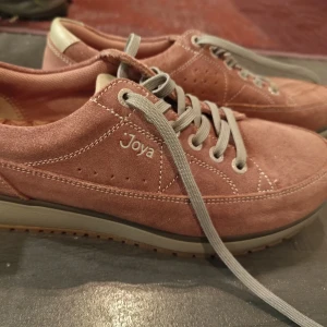 Joya Vancouver sneakers mörkrosa mocka - Snygga sneakers från Joya i mörkrosa mocka med grå snörning och beige detaljer vid hälen. Skorna har en mönstrad innersula och robust yttersula med bra grepp. Perfekta för dig som vill ha både stil och komfort i vardagen. Endast använda innomhus 