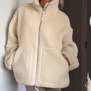 Beige teddyjacka  - Supermjuk och oversized teddyjacka i beige med hög krage och stora fickor framtill. 