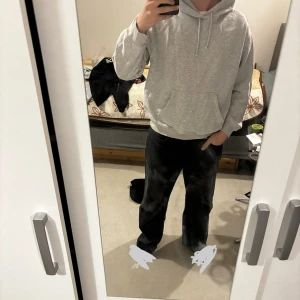 Grå hoodie från H&M, relaxed fit - En stilren ljusgrå hoodie från H&M i relaxed fit. Tröjan har huva med snörning, magficka och ribbade muddar. Perfekt för chill dagar och enkel att matcha med det mesta. Mjuk insida och klassisk look.