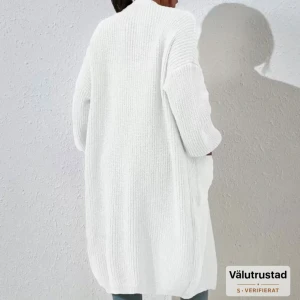 Vit oversized stickad kofta - Lång, oversized stickad kofta i vit färg med stora fickor framtill och breda ärmar. Koftan har en mysig och avslappnad vibe, perfekt att slänga över en crop top och jeans. Ribbstickad struktur ger extra stilpoäng. Köpt för 220