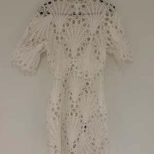Vit spetsklänning med broderade detaljer - Säljer min älskade studentklänning från BYIC i storlek S! 