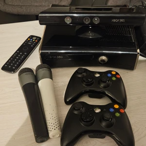 Xbox 360 Kinect, två handkontroller, 2st mikrofoner, 1st fjärrkontroll +massa spel - Xbox 360 med Kinect-sensor, två trådlösa handkontroller, två mikrofoner och fjärrkontroll. Inkluderar flera populära spel som Kinect Sports, Dance Central 3, FIFA 14 och fler. Allt i gott skick, perfekt för familjespel och partykvällar.                Priset går att diskutera så kom gärna med bud