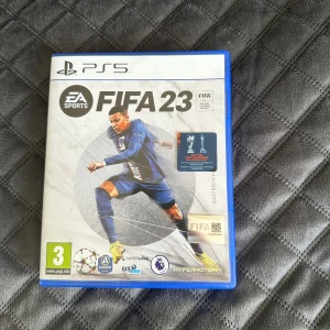 FIFA 23 PS5 - FIFA 23 till PlayStation 5 i mycket fint skick. Komplett med originalfodral och skiva utan synliga repor. Upplev realistisk fotboll med Hypermotion-teknik, över 25 ligor och många spelfunktioner. Perfekt för fotbollsfans och samlare.