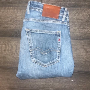 Replay jeans  - Säljer ett par replay jeans  i ljusblå tvätt med klassiska femficksdetaljer och läderpatch bak. Jeansen har en slim passform och raka ben, tillverkade i mjukt bomullsjeans. Perfekta för dig som gillar en modern och stilren look. Midja 40,5cm, längd 96cm. Storleks och modelllapp är borta men jag bedömer storleken till W32 L32 kanske L30. Men utgå från måtten noggrant ! Modellen är Willby :) 11