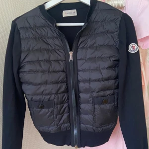 Moncler äkta svart cardigan Dam - Svart dam cardigan jacka från Moncler med quiltad framsida och två fickor. Varan har inga defekter/tecken på användning. Samt äkthetsbevis finns. Det finns fler bilder om det önskas. Priset går att diskutera så hör av dig vid intresse! 