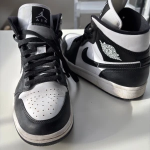 Nike Air Jordan 1 svartvita sneakers - Säljer ett par klassiska Nike Air Jordan 1 i svart och vitt skinn.