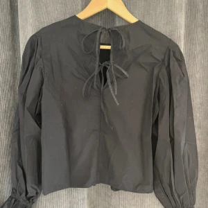 Svart blus med knyte bak - Svart blus med knyte bak, endast använd en gång