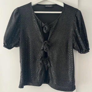 Glittrande topp med rosett framtill - Jättefin glittrande topp men öppningsbara rosetter från till som man kan knyta om lite hur man vill! Perfekt inför lite festligare stunder, eller varför inte på nyår?!😍