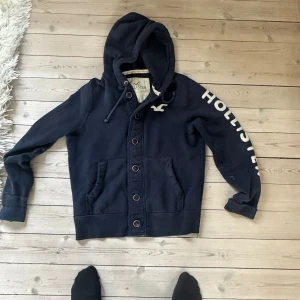 Mörkblå Hollister hoddie/cardigan vintage.  - Väldigt fint skick denna säljs inte längre och är sjukt populär! Tveka inte att fråga frågor eller skriva vid intresse. Modell är 182