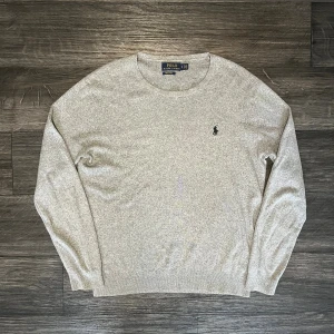 Ralph Lauren sweatshirt grå - Snygg grå långärmad tröja från Polo Ralph Lauren i mjuk pima bomull. Klassisk rund hals och diskret broderad logga på bröstet. Perfekt för dig som gillar stilrena och enkla plagg med premiumkänsla. Om du har funderingar kring plagget är det bara att skriva Mvh FABIANFASHION 