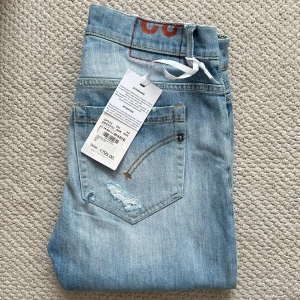 HELT NYA Dondup George skinny fit  - HELT NYA Dondup George skinny fit, storlek W32, MEN modellen bär W32 och är 180 cm 75 kg. Mått A: 40 cm. B: 103 cm. Väldigt snygga och sköna! Väldigt bra pris med tanke på att dom är helt nya med nypris på ungefär 2600 sek. Kom gärna med frågor! ✌️