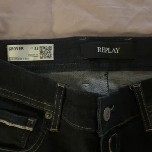 Replay Grover jeans straight fit mörkblå - Säljer ett par Replay Grover jeans i straight fit med mörkblå tvätt och klassiska kontrastsömmar. Jeansen har fem fickor och tydlig Replay-logga i linningen. Perfekta för dig som gillar en clean och tidlös look.