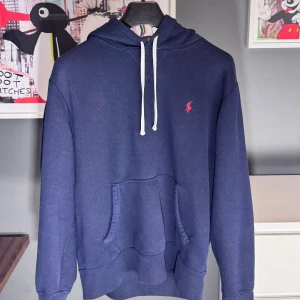 Mörkblå hoodie från Polo Ralph Lauren - Vi säljer nu denna mörkblå hoodie från Polo Ralph Lauren med vita snören. Size M Cond: 8,5/10 Nypris: 2400 kr - Vårt pris 799 kr. 