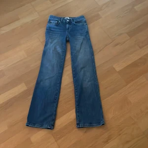 Blå bootcut jeans med raka ben - Snygga blå jeans med bootcut och raka ben. Supersnygga fickor med knappar. 