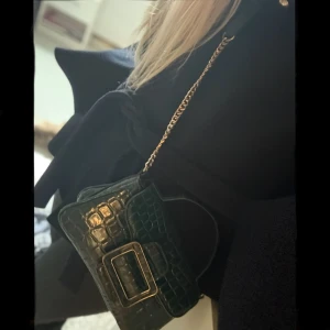 Liten axelväska med kedja - Snygg mörkgrön axelväska i coolt mönster. Knappt använd så i jättebra skick! Skriv för fler bilder! 