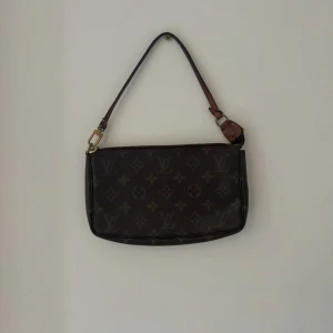Louis Vuitton Pochette - Säljer en Louis Vuitton Pochette väska i fint vintage skick men finns täcken på användning som man ser på bilderna. Inga fläckar eller någon konstigt lukt i väskan. 