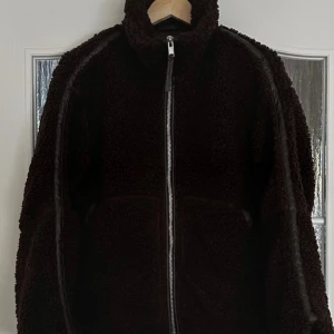 Mörkbrun teddyjacka med dragkedja XS - Populär hm jacka Teddy lapp kvar. Mysig mörkbrun teddyjacka i storlek XS med hög krage och hel dragkedja framtill. Jackan har en oversized passform 