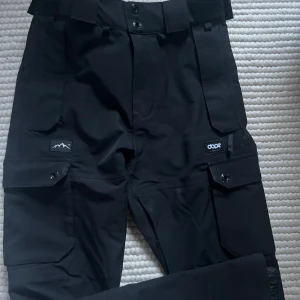 Skidbyxor från dope snow - Svarta skidbyxor från dope snow. Storlek xs, använda men i gott skick, mycket funktionella fickor både på benen och baktill