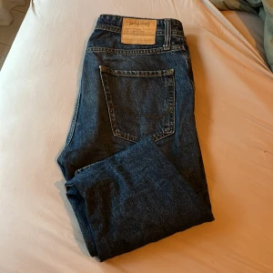 Blå relaxed jeans från Jack & Jones - Säljer ett par blå jeans från Jack & Jones i modellen Relaxed/Chris. Jeansen har klassisk femficksdesign, normal midja och raka ben. Materialet är slitstarkt denim i bomull och passformen är loose för en avslappnad vibe.