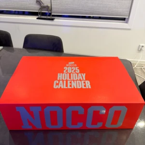 NOCCO 2025 Holiday Calender - NOCCO 2025 Holiday Calender i originalförpackning. Snygg röd box, perfekt som present eller för att njuta av NOCCO-produkter under december. Kartongen är helt ny ut utan slitage eller skador.
