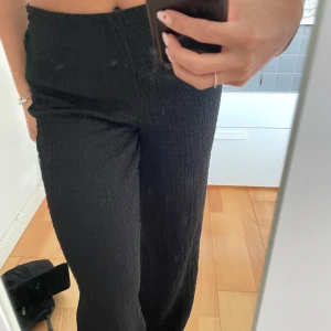 Svarta byxor med textur  - Sköna svarta byxor med textur som endast är använda 1 gång. Snygga men bekväma!!