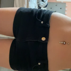 Svarta low waist jeans shorts - Säljer ett par svarta, tighta shorts med låg midja. Väldigt lätt att röra sig i och nytt skick. Storlek S tror jag men passar även mig som är XS💓