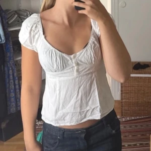 Gullig topp blus smock slutsåld trendig populär trendy stockholmsstil babydoll milkmaid coquette puffärm - Söt topp med fina detaljer från Brandy Melville. One size, men passar nog bäst som XS/S.