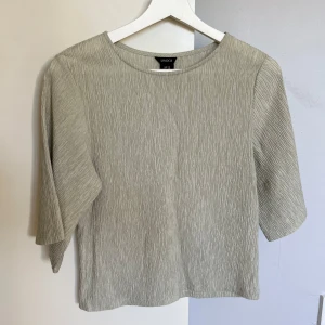 Ljusgrön blus - Säljer en ljusgrön blus från Lindex med snyggt strukturerat tyg och lite större trekvartsärmar. Blusen har en rak passform och rund halsringning, perfekt för en clean och stilren look. Även väldigt luftig och skön.