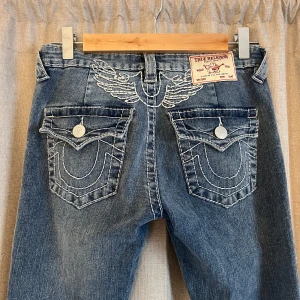 True Religion bootcut jeans blå, stl 26 - Säljer ett par blå bootcut jeans från True Religion för jag aldrig använt dom och tycker inte dom passar mig💕💕skriv om detaljer 