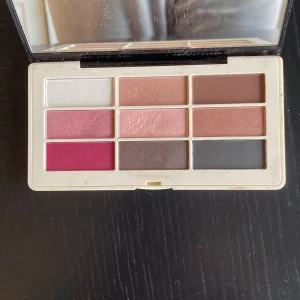 Twilight and Rose ögonskuggspalett H&M - Snygg ögonskuggspalett från H&M med 9 nyanser i rosa, nude, brunt, vitt, grått och mörkrosa. Paletten har både matta och skimriga färger och kommer i ett smidigt fodral med spegel. Perfekt för att skapa allt från softa till mer dramatiska looks.Endast 4 färger testade på handen.