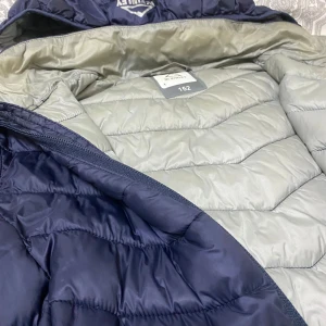 Mörkblå pufferjacka från KIWILEY - Säljer en mörkblå pufferjacka från KIWILEY med huva och dragkedja framtill. Jackan har två sidofickor med dragkedja och är fodrad i ljusgrått. Perfekt för kalla dagar och riktigt skön att bära.