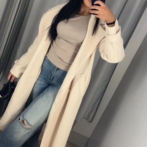 Beige lång kappa  - Används inte längre.