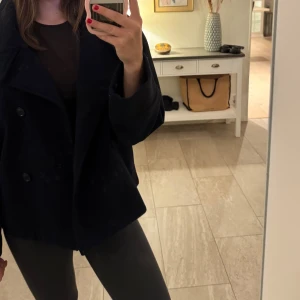 Svart kappa från Gina Tricot  - En snygg svart kappa från Gina. Använt en gång och har ingen användning för. Vet inte orginalpris men säljer för bra pris.🥰