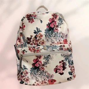 Vit blommig ryggsäck med dragkedja - Superfin ryggsäck i vitt med blommigt mönster i rosa, rött och blått. Väskan har justerbara axelband, praktiskt ytterfack med dragkedja och är tillverkad i ett syntetmaterial med lätt struktur. Perfekt för dig som vill ha en söt och unik accessoar till vardagen. 
