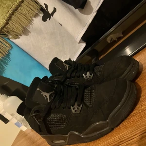 Nike Air Jordan 4 Retro Black Cat - Säljer ett par Nike Air Jordan 4  Black Cat. Helt svarta skor. Jumpman-loggor på plös och häl. Har haft dom ganska länge nu därför säljer jag dom.