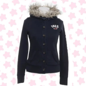 Mörkblå hoodie med päls från Hollister - Snygg mörkblå hoodie från Hollister med päls runt huvan och knappar framtill. Pris diskuteras!🍓