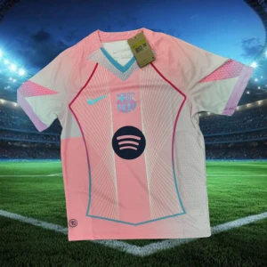 Barcelona fotbollströja Nike - Snygg FC Barcelona fotbollströja i rosa och vitt med ljusblå detaljer. Tröjan har korta ärmar, klubbmärke och Nike-logga på bröstet samt Spotify-logga i mitten. Tillverkad i lätt och ventilerande material, perfekt för match eller träning.