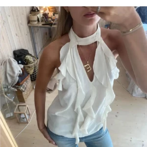 Vit omlott halterneck blus med volang - Intressekoll på denna vita blusen från Zara, jätte fin men kommer ej till användning!Är inte säker på om jag vill sälja så kom med prisförslag eller skriv innan ni köper så jag kan bestämma mig!! Bilderna är lånade så skriv även om ni vill se egna bilder!!❤️❤️