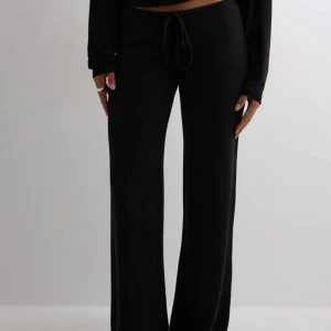 Nelly mjukisbyxor - Svarta mjukisbyxor från Nelly i modellen My Chill Pants. Byxorna har en relaxed passform med vida ben, låg midja och snörning i midjan. Perfekta för en chill och avslappnad stil. Mjukt material som känns skönt mot huden. Säljer pga de inte passade! Köpta nya för 349kr men säljer för 300 då jag glömde skicka tillbaka!