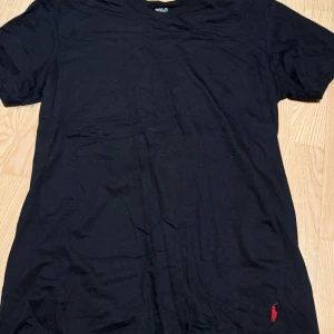 Svart t-shirt från Polo Ralph Lauren - Storlek L. Aldrig använd men köpt i flerpack sà därav sitter det ingen lapp kvar. Kvitto finns om sà behövs. Säljer då svart inte är min färg. Tillverkad i 100% bomull och har den ikoniska lilla broderade loggan i mörkblätt nedtill. Perfekt basic-plagg med skön passform..