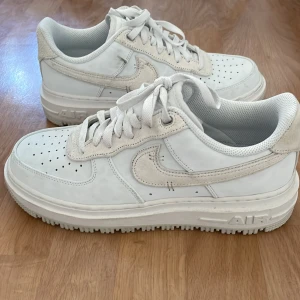 Nike Air Force 1 Luxe vita sneakers - Helt nya och oanvända.  Perfekta höst/vinterskor. Nike Air Force 1 sneakers i helvitt med detaljer i mocka och klassisk snörning.. Perfekta för en clean och stilren look. 
