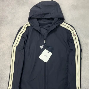 Moncler olan windbreaker jacket - – Condition: 10/10 - brand new  - Size: 4/XL  – Retail price: 11 575 SEK  Please note that Moncler runs small, we recommend going up one size from your usual size.