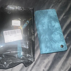 Samsung Galaxy S24 FE Plånboksfodral - Ny blå plånboksfodral till Samsung Galaxy S24 FE. Fodralet har flera kortfack, magnetlås och dragkedja för extra förvaring. Passar perfekt och skyddar din mobil mot repor och stötar. Inga synliga defekter, levereras i originalförpackning.