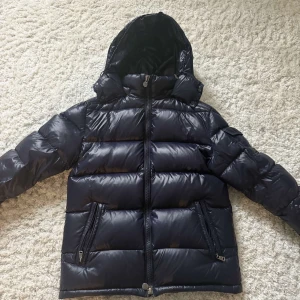 Moncler Maya size 2 - Säljer min moncler maya, använd 2 vintrar. Inga hål eller andra defekter. NFC funkar som den ska. hör gärna av dig om du har frågor så ska jag svara snabbt jag kan.