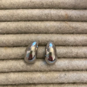 Chunky silverfärgade örhängen formade som regndroppar - Säljer ett par chunky örhängen i silverfärg med droppformad och böjd design. 